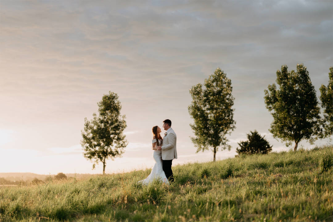 MWB37_The Riverstone Estate_long grass paddock_bride and groom_green trees_sunset The Riverstone Estate